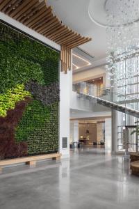 a large green wall in a lobby with a staircase at Marriott Virginia Beach Oceanfront Resort in Virginia Beach