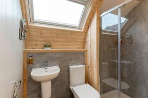 a bathroom with a toilet and a sink and a window at Country Glamping in Bishop Auckland