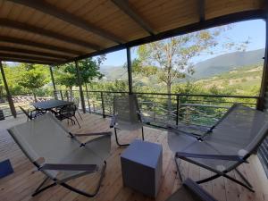 eine Terrasse mit Stühlen und Tischen sowie Bergblick in der Unterkunft Camping Villaggio Il Collaccio in Preci