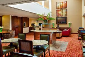 a hotel lobby with tables and chairs and a tv at Sacramento Marriott Rancho Cordova in Rancho Cordova