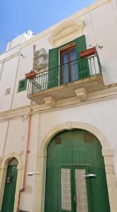a building with a green door and a balcony at LA DIMORA DEL PRINCIPE - Relaxing Private Terrace & City View in Polignano a Mare