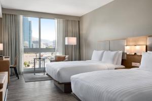 a hotel room with two beds and a window at AC Hotel by Marriott Cape Town Waterfront in Cape Town