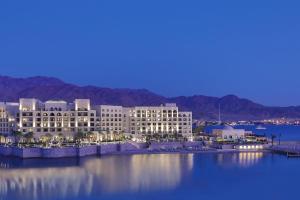 Al Manara, a Luxury Collection Hotel, Aqaba في العقبة: مبنى كبير جالس على سطح ماء
