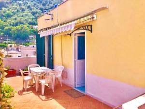 a patio with a table and chairs on a house at Appartamento Centrale in Ischia Town