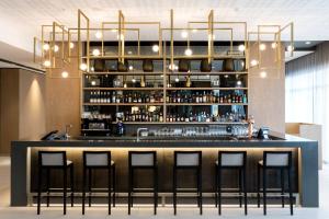 a bar with a black counter with bar stools at AC Hotel by Marriott Cape Town Waterfront in Cape Town