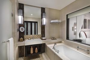 a bathroom with a bath tub and a sink at Al Manara, a Luxury Collection Hotel, Aqaba in Aqaba