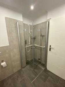 a shower with a glass door in a bathroom at Ferienwohnung Ostseetraum in Damp