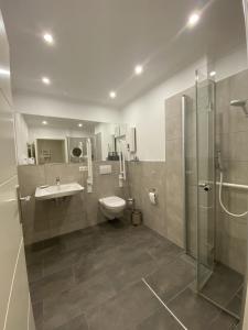 a bathroom with a toilet and a sink and a shower at Ferienwohnung Ostseetraum in Damp