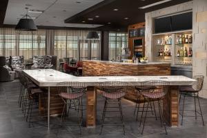 a bar with a large marble counter and bar stools at Courtyard by Marriott Las Cruces at NMSU in Las Cruces