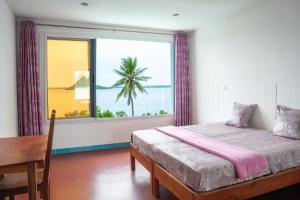 1 dormitorio con cama, mesa y ventana en villa piscine à louer a DIEGO SUAREZ. MADAGASCAR, en Antsiranana