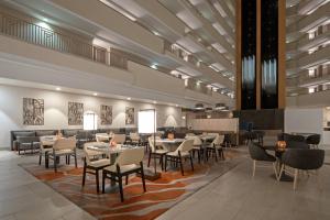 a restaurant with tables and chairs in a lobby at Tucson Marriott University Park in Tucson