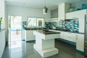 a kitchen with white cabinets and a black counter top at villa piscine à louer a DIEGO SUAREZ. MADAGASCAR in Diego Suarez