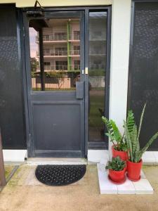 an open door with potted plants in front of it at Boutique Granny Flat in Paraparap