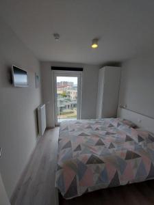 um quarto com uma cama e uma grande janela em Karthuizer Duinpoort em Nieuwpoort