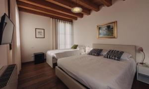 a bedroom with two beds and a flat screen tv at La Costa in Sarcedo