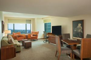 um quarto com uma sala de estar com uma secretária e uma televisão em Sheraton Boston Hotel em Boston