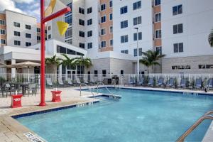 椰子溪的住宿－Residence Inn Fort Lauderdale Coconut Creek，一座带椅子的酒店游泳池,一座建筑