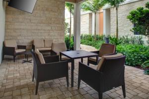 Residence Inn Fort Lauderdale Coconut Creek في كوكونت كريك: فناء به طاولات وكراسي على فناء