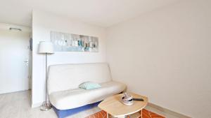 a living room with a white couch and a table at Terrasses de la Plage- 257- Appart moderne- 4 pers in Cap d'Agde