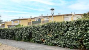 a hedge in front of a building with a street light at Terrasses de la Plage- 257- Appart moderne- 4 pers in Cap d'Agde