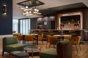 um restaurante com mesas e cadeiras e um bar em Courtyard by Marriott Fresno Clovis em Clovis