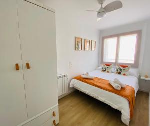 een witte slaapkamer met een bed en een raam bij Casa Ibicenca en Benicasim a 3 minutos de la playa in Benicàssim