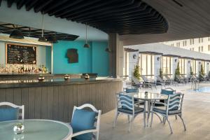 a restaurant with tables and chairs and a bar at Sheraton Amman Al Nabil Hotel in Amman