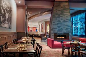 un restaurante con mesas y sillas y una chimenea en Marriott Raleigh City Center, en Raleigh