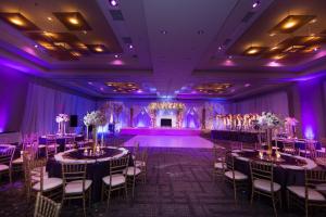 einen Bankettsaal mit Tischen, Stühlen und lila Beleuchtung in der Unterkunft Raleigh Marriott City Center in Raleigh