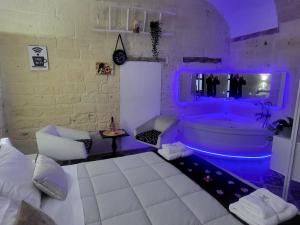 a bedroom with a tub with purple lights in it at QUART0 GREC0 Suite 17 in Altamura