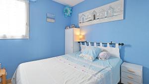 1 dormitorio con paredes azules y 1 cama con 2 almohadas en Port Lano- 109- Appart lumineux- 4 pers, en Cap d'Agde