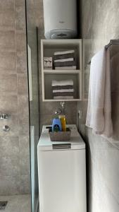 a bathroom with a toilet and a shower with towels at Apartment Downtown in Podgorica
