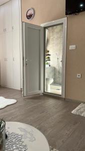 una stanza vuota con una porta che si apre su un bagno di Apartment Downtown a Podgorica