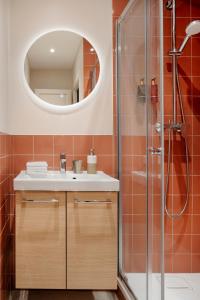 La salle de bains est pourvue d'un lavabo et d'une douche. dans l'établissement Edgar Suites Grands Boulevards - Boulanger, à Paris