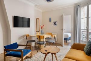 sala de estar con mesa y sillas en Edgar Suites Grands Boulevards - Boulanger, en París