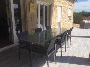 szklany stół i krzesła na patio w obiekcie Villa Emma 10 / 12 personnes w mieście Grignan