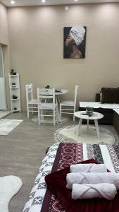 a living room with a table and a picture of a man at Apartment Downtown in Podgorica