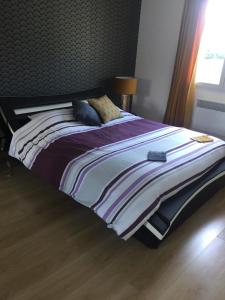duże łóżko z fioletowo-białymi kocami i poduszkami w obiekcie Villa Emma 10 / 12 personnes w mieście Grignan