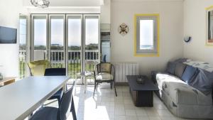 uma sala de estar com um sofá e uma mesa em Aquaplage- 105B- Studio vue mer- 5 pers em Cap d'Agde