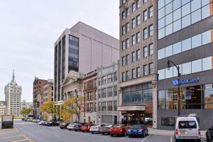 een stadsstraat met auto's geparkeerd voor gebouwen bij Fairfield Inn & Suites by Marriott Albany Downtown in Albany