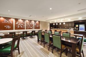 TownePlace Suites by Marriott Slidell في سليدل: غرفة طعام مع طاولات وكراسي خضراء