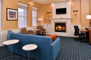 a lobby with a fireplace and a couch and chairs at Fairfield Inn & Suites by Marriott Albany Downtown in Albany