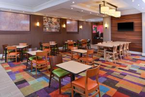 une salle à manger avec des tables et des chaises sur un tapis coloré dans l'établissement Fairfield Inn & Suites by Marriott Albany Downtown, à Albany