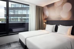 two beds in a hotel room with a window at STAGES HOTEL Prague, a Tribute Portfolio Hotel in Prague