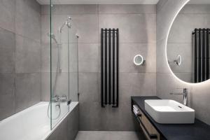 a bathroom with a tub and a sink and a mirror at STAGES HOTEL Prague, a Tribute Portfolio Hotel in Prague