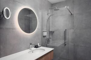 a bathroom with a sink and a shower with a mirror at STAGES HOTEL Prague, a Tribute Portfolio Hotel in Prague