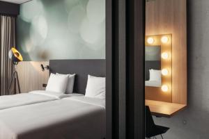 a hotel room with a bed and a mirror at STAGES HOTEL Prague, a Tribute Portfolio Hotel in Prague