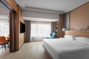 1 dormitorio con cama, escritorio y silla en Surat Marriott Hotel, en Surat