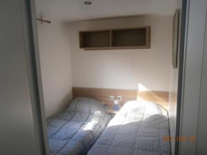 een slaapkamer met 2 bedden en een raam bij Mobilhome 3 chambres tout confort, proche de la plage in Saint-Brevin-les-Pins