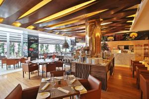 a restaurant with wooden ceilings and tables and chairs at Cali Marriott Hotel in Cali